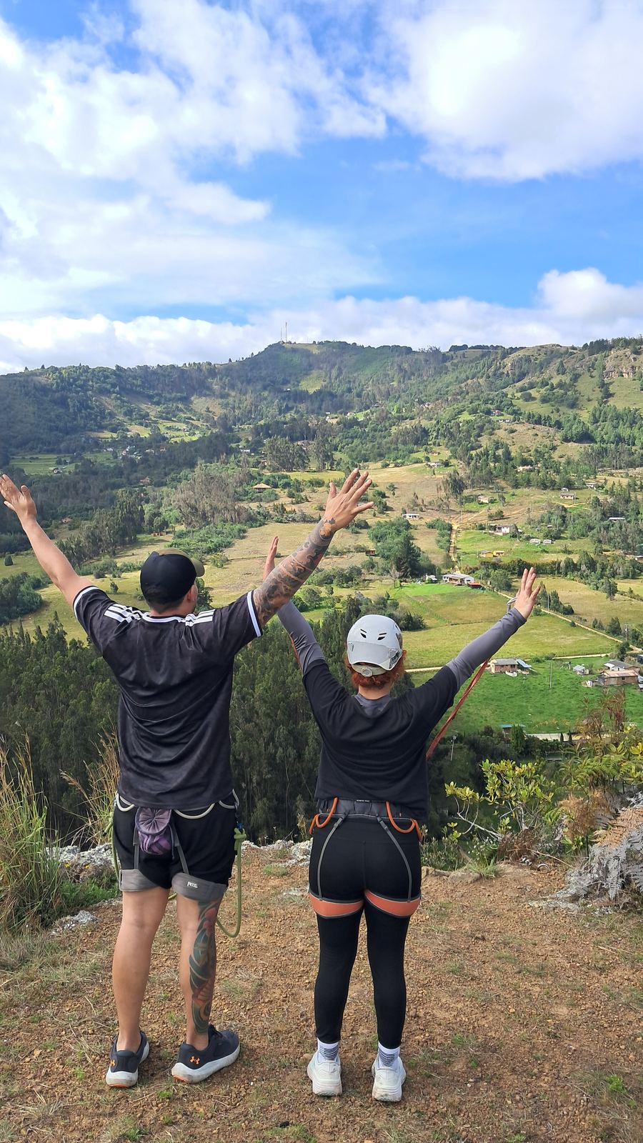 Dos participantes con los brazos abiertos frente al valle de Suesca