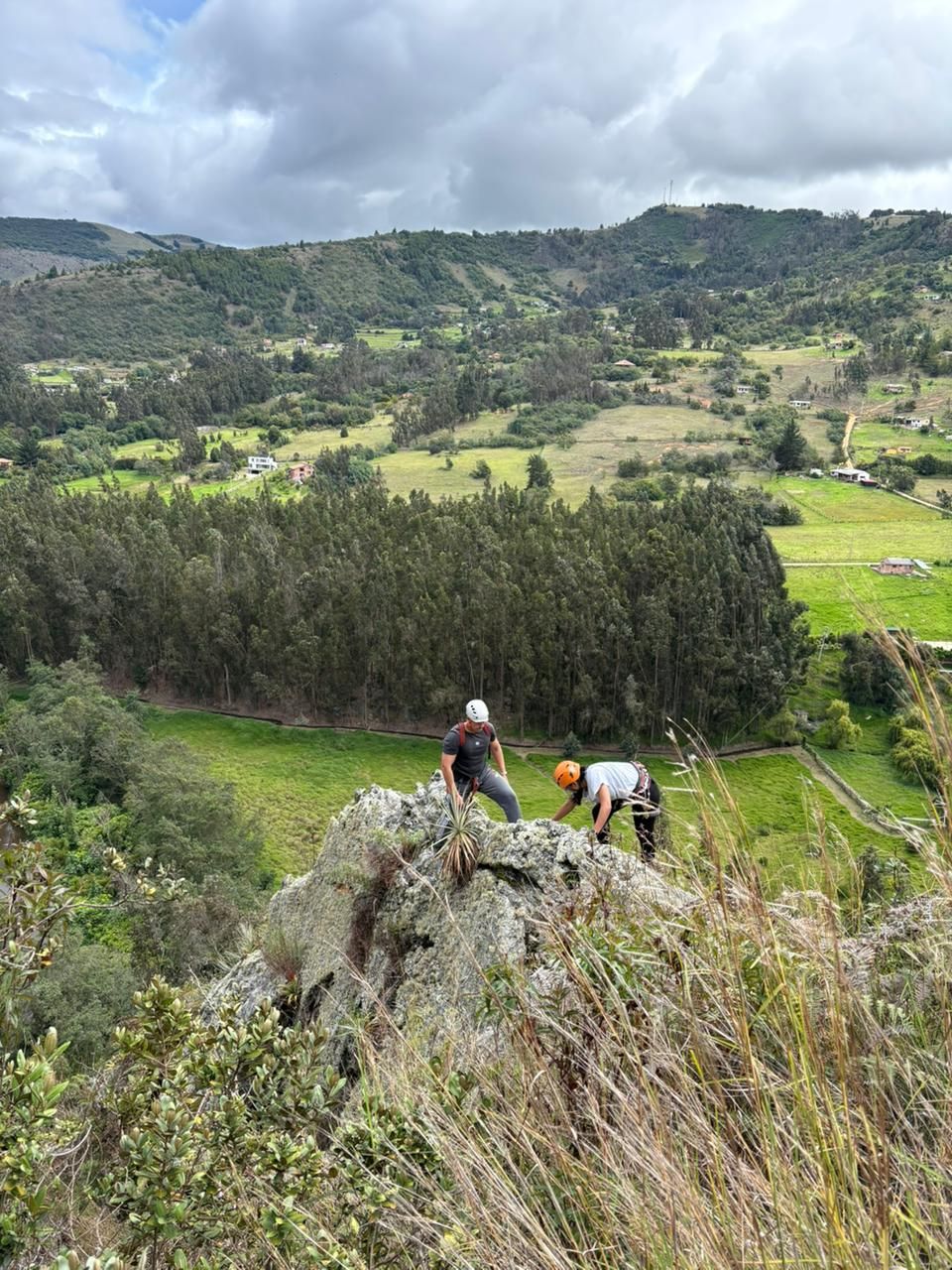 Escaladores en la roca frente al valle de Suesca